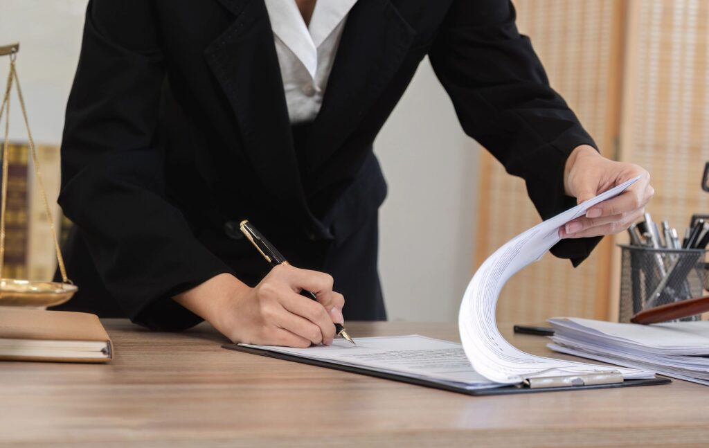 Person signing documents at a desk.