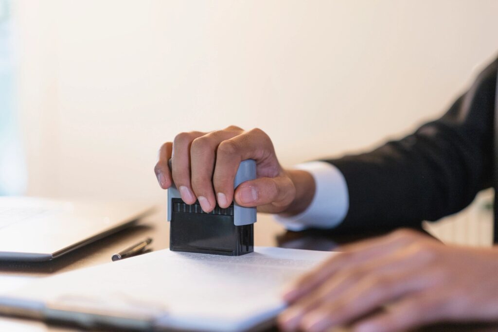Person stamping a document at desk.