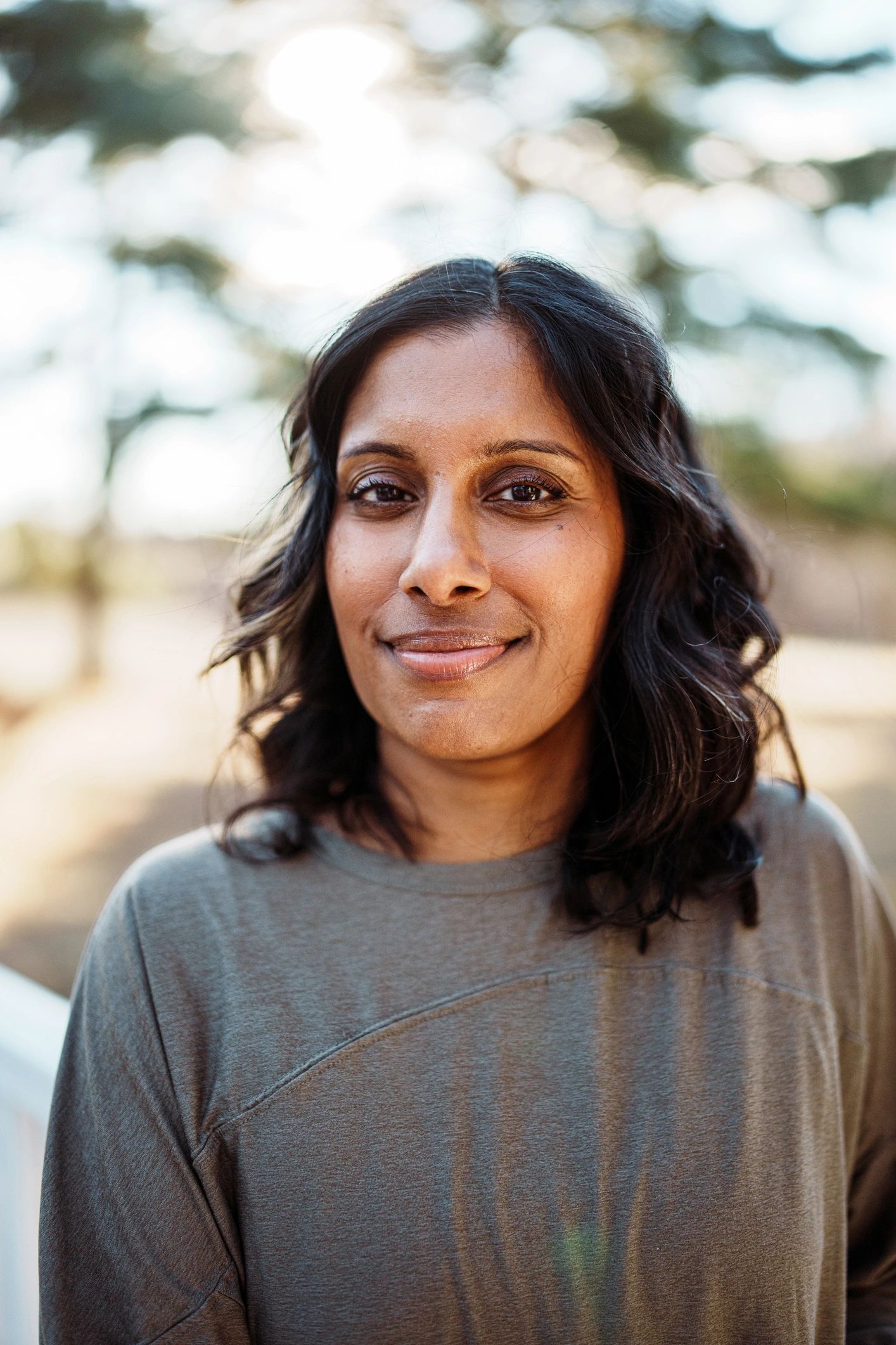 Portrait of a woman with long dark hair smiling gently.